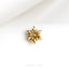 a gold brooch sitting on top of a white cloth
