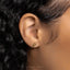 a close up of a person's ear wearing a gold earring