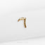a small gold letter on a white surface