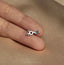 a person&#39;s hand holding a tiny silver ring