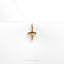 a gold cross charm on a white background