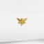 a gold bee pin sitting on top of a white sheet