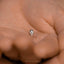 a tiny diamond ring sitting on the palm of someone&#39;s hand