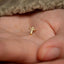 a small gold cross on a person's hand
