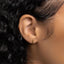a close up of a person&#39;s ear with a small cross on it
