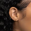 a close up of a person's ear with a small cross on it