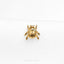 a gold beetle brooch sitting on top of a white cloth