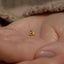 a baby&#39;s hand with a tiny gold nose ring