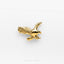a gold bird brooch sitting on top of a white surface