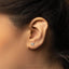 a close up of a person&#39;s ear with a small diamond