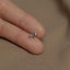 a person&#39;s hand holding a tiny silver dog ring