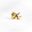 a gold cat brooch sits on a white surface
