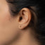 a close up of a person's ear with a gold earring