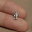 a person&#39;s finger with a small silver elephant charm on it