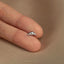a person's hand holding a tiny silver nose ring