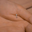 a person's hand with a tiny diamond ring on it