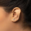 a close up of a person's ear with a single diamond