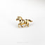a gold horse brooch sits on a white surface