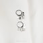 a pair of silver earrings sitting on top of a white cloth