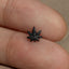 a person&#39;s finger with a small black and white flower on it