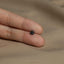 a person's hand holding a tiny black marijuana leaf