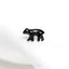 a small black bear sitting on top of a white cloth