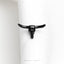 a black bull skull ring on a white napkin