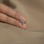 a person's hand holding a ring with a cross on it