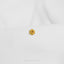 a close up of a white shirt with a gold flower on it