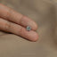 a person's hand holding a diamond ring