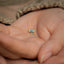 a person's hand holding a tiny blue butterfly stud