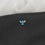 a close up of a blue and white cross on a black bag