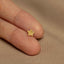 a person's hand holding a tiny gold star of david ring