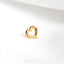 a gold heart shaped ring on a white surface