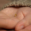 a tiny gold ring is held in someone's hand