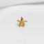 a gold starfish pin sitting on top of a white surface