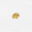 a golden hedgehog brooch sits on a white surface