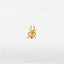 a gold spider ring sitting on top of a white sheet