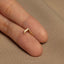 a person's finger with a gold ring on it