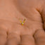 a tiny gold deer head on a person's hand