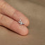 a person's hand holding a tiny ring with a bird on it