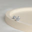 a pair of silver earrings sitting on top of a white plate