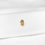 a close up of a gold brooch on a white shirt