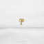 a pair of gold earrings on a white cloth
