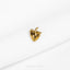 a close up of a gold brooch on a white cloth
