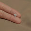 a person&#39;s hand holding a tiny diamond ring