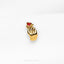 a gold brooch with a red heart on it