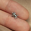 a small silver cat charm sitting on top of a persons finger