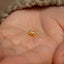 a tiny gold nose piercing on a person's hand