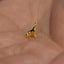 a small gold dog charm sitting on a persons hand